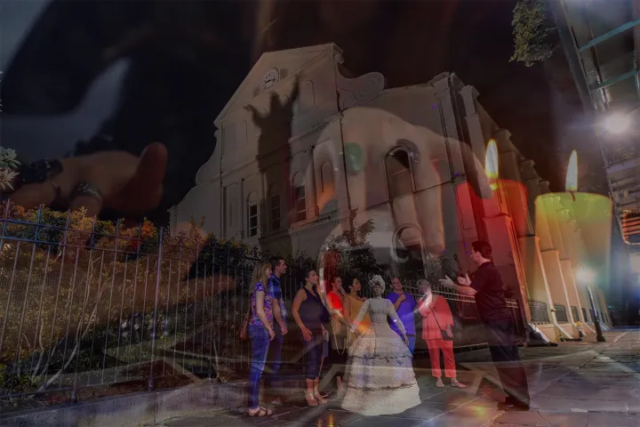 Overlay of a nighttime tour group in front of a historic building with candles and hands in the background.